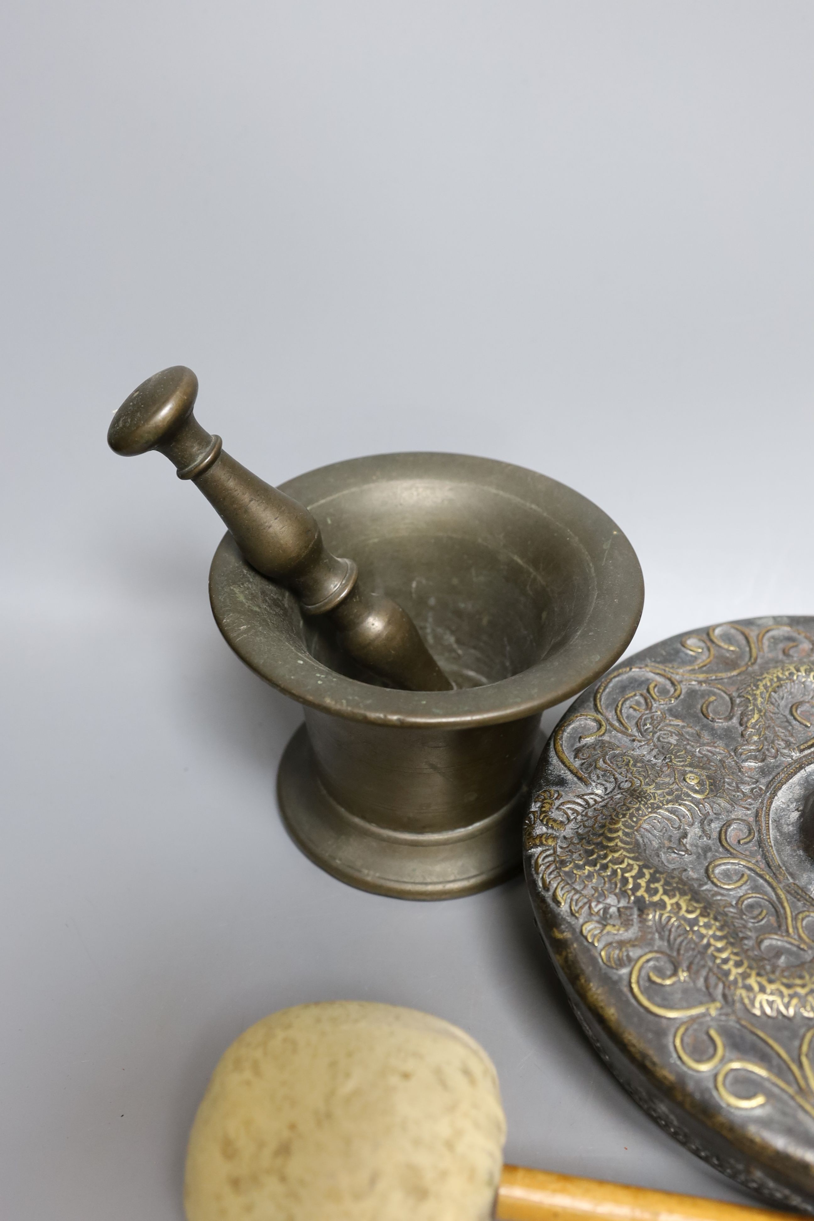 Two pestles and mortars and a Chinese gong with beater, gong 21 cms wide.